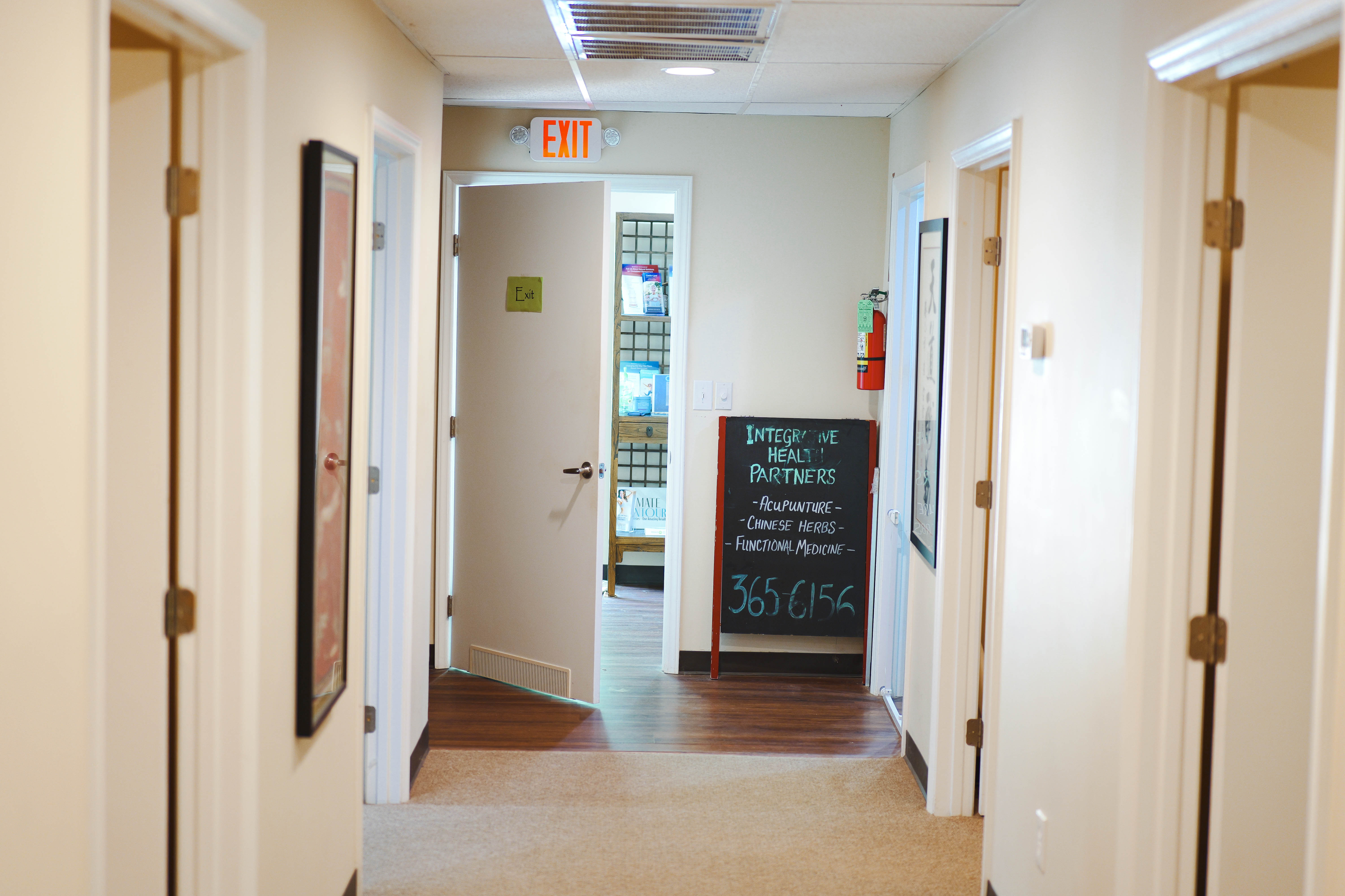 IHP clinic hallway with chalkboard listing Acupuncture, Chinese Herbs, and Functional Medicine — call 365-6156